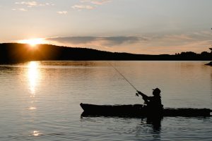 Silhouette of Man in Boat Fishing